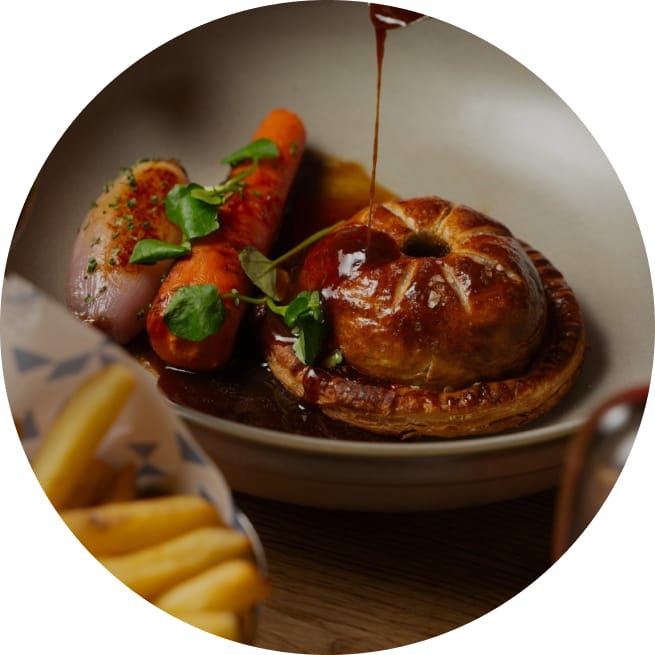 gravy being poured over pastry and vegetables