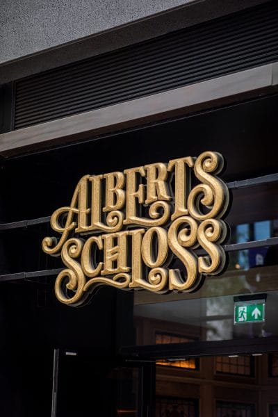 entrance sign of albert schloss an alpine german restaurant