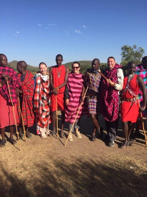 tourists wearing traditional clothing in a group of local people