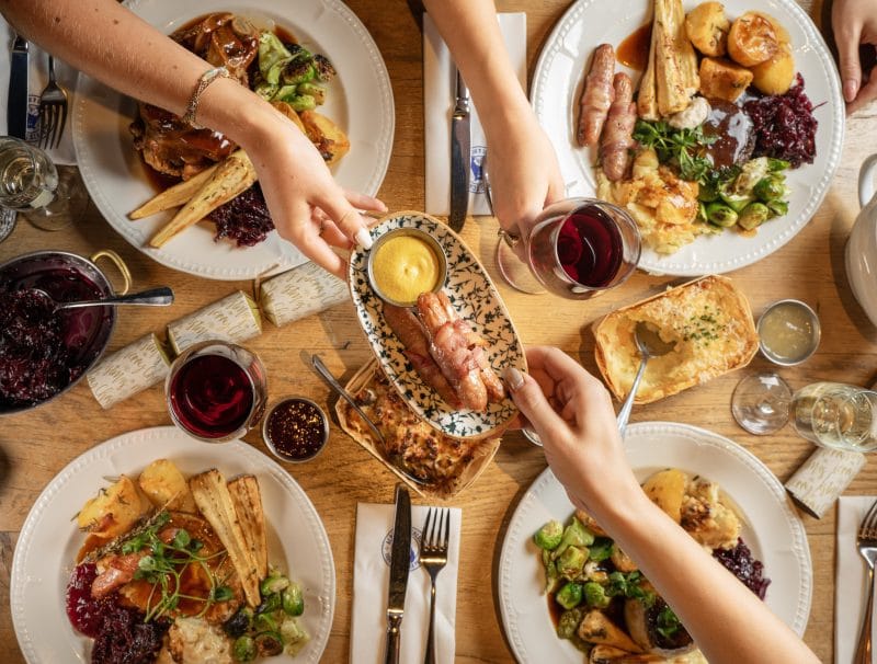 people grabbing plates at christmas table